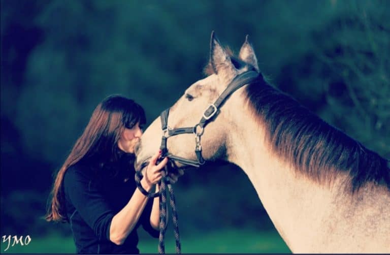 photo de Véronique embrassant sur les naseaux Ulixia, son cheval fétiche à la robe caramel